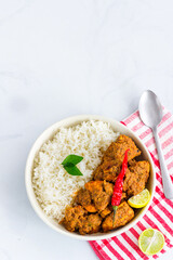 South Indian Stir-Fried Chicken with Rice in a Bowl Garnished with Curry Leaves Vertical Photo