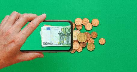 Money paper euro banknotes on the background of a smartphone screen, cents on a green background, the concept of business, investment and income growth