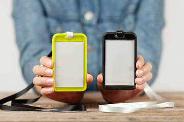 Two name tag mockup in hands. Corporate badges, empty business label for personal identity of people.