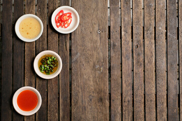 Flavoring food on wooden background at restaurant.