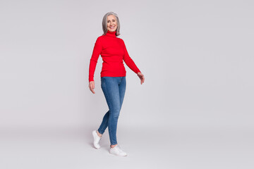 Full length profile side photo of cheerful senior woman happy positive smile go walk step isolated...