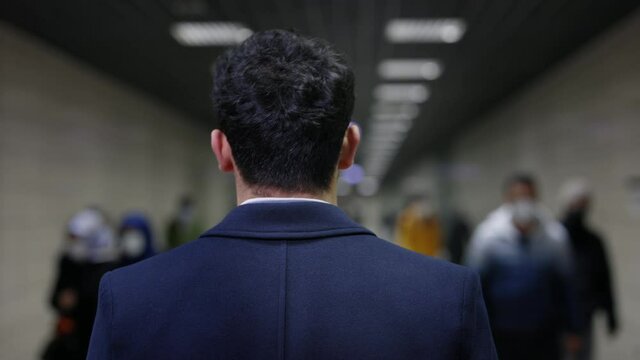 Back view of businessman walking on metro station