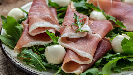 Antipasto salad with prosciutto, mozzarella cheese and arugula, Antipasti, a traditional Italian, Food recipe background. Close up
