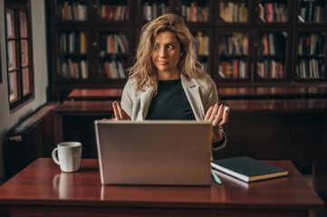 Businesswoman using a laptop for an online meeting while working in her office