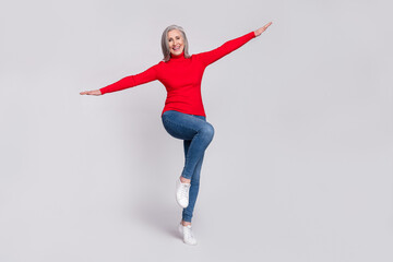 Full body photo of cheerful aged woman happy positive hands wings fly isolated over grey color background