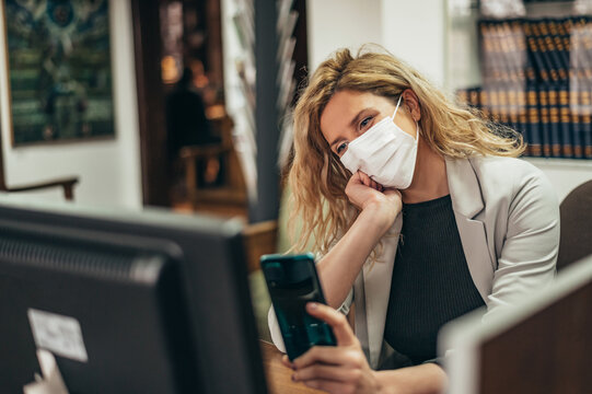 Businesswoman wearing protective mask at work while taking a selfie with a smartphone