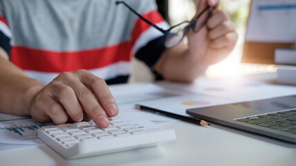 Businessman pen pointing graph chart in this mounth and use calculator for Plans to improve quality next month.