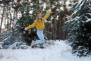 Cheerful woman enjoying winter day in forest
