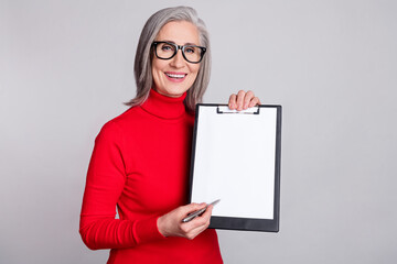 Photo of aged woman happy positive smile show clipboard papers sign signature pen isolated over...