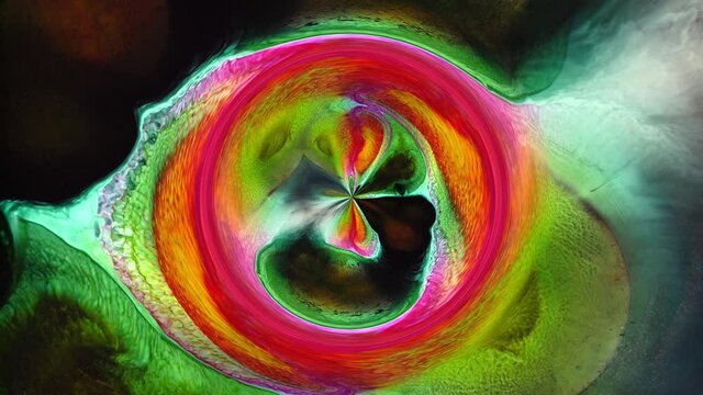 Bright red pink green colorful abstract circles rotation. Chemical reaction of vivid liquid paint in water, Big Bang, Space, God's Eye, Universe. Fluid art
