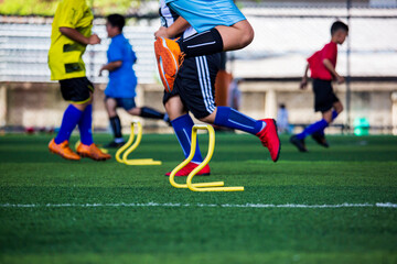 Soccer ball tactics on grass field with barrier for training children jump skill