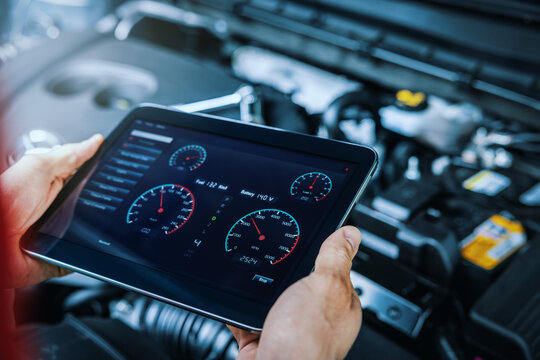 car engine diagnostics. service mechanic using digital tablet to inspect vehicle condition