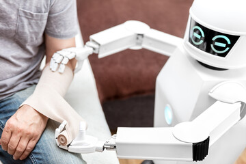 robot is putting a bandage on a arm of an male patient