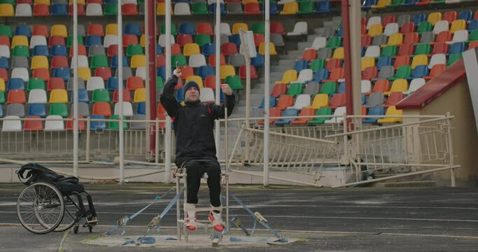 Spear throwing training Paralympian man with defective legs sitting in a wheelchair Exercise for training hands on the street outside the stadium