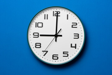 Retro clock on blue table background, vintage style