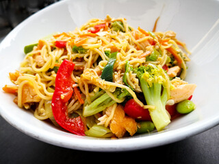 Asian dish Pad Thai prepared with noodles, grilled shrimps, soy sprouts, carrots pieces and sprinkle with peanuts to serve a delicious meal