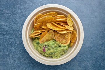 Top view of a portion of fried plantain chips with guacamole. - obrazy, fototapety, plakaty