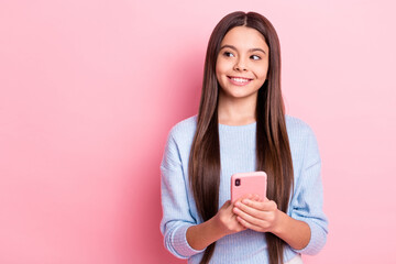 Portrait of attractive cheerful girl using device creating post smm idea isolated over pink pastel color background