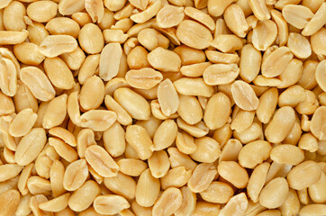 Roasted and salted peanuts, background, from above. Snack food, made from fruits of Arachis...