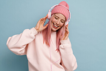 Young woman dancing while listening music with headphones