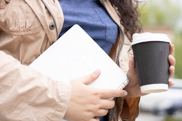 young business woman standing with laptop and cup of coffee 