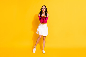 Full length body size view of attractive cheerful amorous wavy-haired girl sending air kiss isolated over bright yellow color background