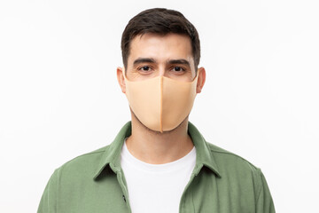 Young man wearing trendy green cargo shirt and beige mask standing isolated on gray background