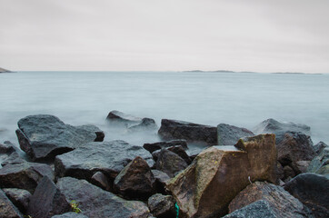 Long exposure photo of beautiful cold ocean waves and rocks. Seasonal. Swedish West coast.