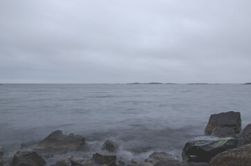 Long exposure photo of beautiful cold ocean waves and rocks. Seasonal. Swedish West coast.