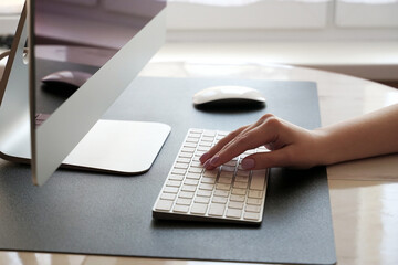 Work at home. Typing on the keyboard. Working at the computer remotely of a young girl.