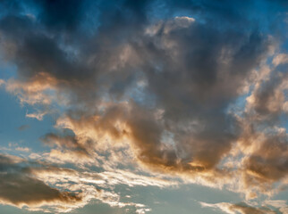Obraz premium Orange Clouds in Evening Light of Sunset on Blue Sky Background - Overcast Western Sky in Spring Dusk Time - Belarus Minsk