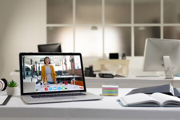 Asian woman having business video call on screen of laptop on desk