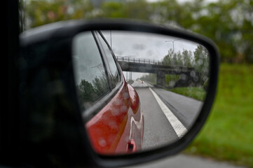 Fototapeta premium looking through side mirror at bridge over highway