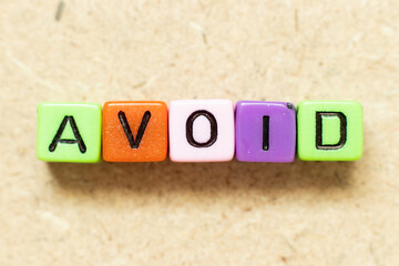 Color alphabet letter block in word avoid on wood background