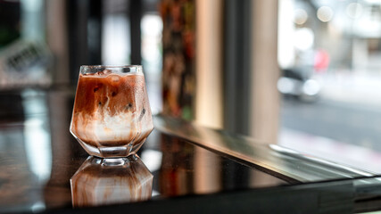 Close-up of iced coffee served on black table at cafe​