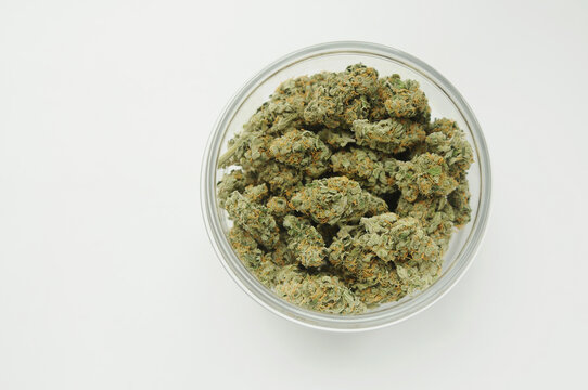Marijuana product, trimmed buds in a jar. Medicinal cannabis stuff on white background, isolated, top view. CBD recreation, medical usage, pastime therapy.