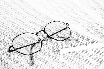 finance business calculation with glasses, tables with numbers and pen. business concept. financial...