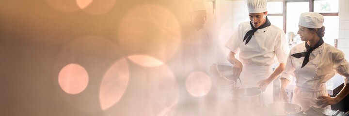 Composition of male and female chefs in kitchen with spots of light