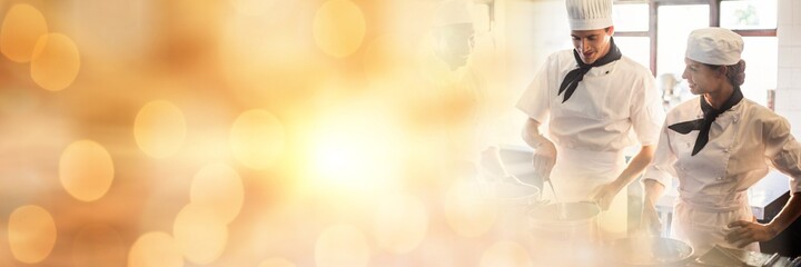 Composition of male and female chefs in kitchen with spots of light