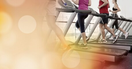 Composition of people running on treadmill spots of light