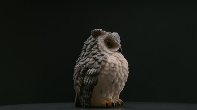 Ceramic owl souvenir figure rotating 360 on black background