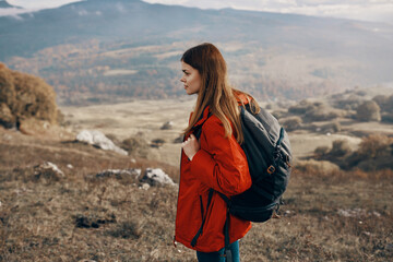 woman in a jacket travel in the mountains outdoors fresh air model