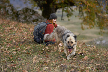 woman hiker with dog in the mountains admires nature travel