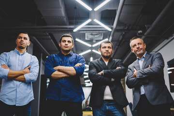 Half length of masculine businessmen with crossed hands looking away during working time in firm office, confident professional experts have collaborative brainstorming for building dream team