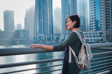 Happy young female traveler in the big city of Dubai, UAE