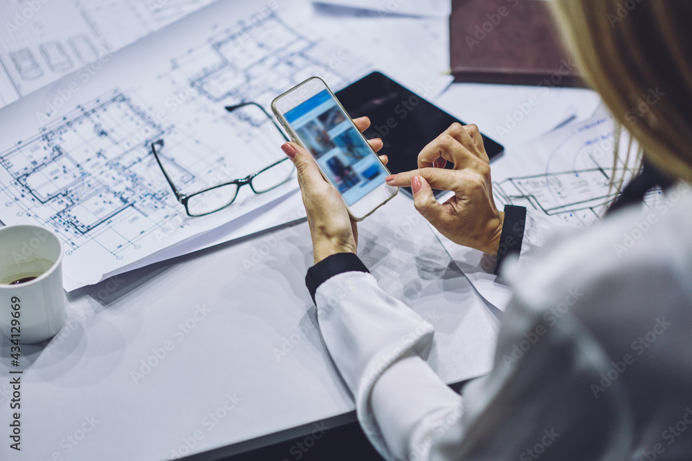 Aufkleber unrecognizable business woman using cellular application for checking online sketches during working