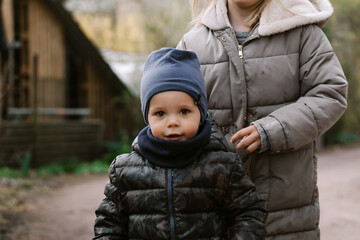 smiling toddler and his sister outdoors