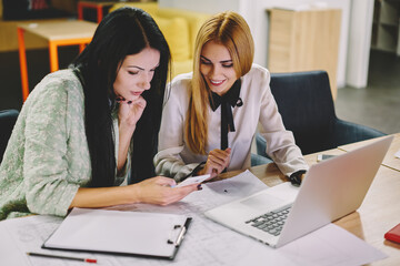 Young female employee using modern smartphone gadget for making online booking and banking during working time in office interior, Caucaisan women talking about business innovations and trade