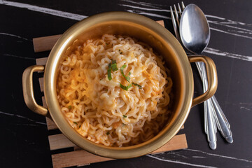 spicy instant noodle in a golden pot with mozzarella cheese