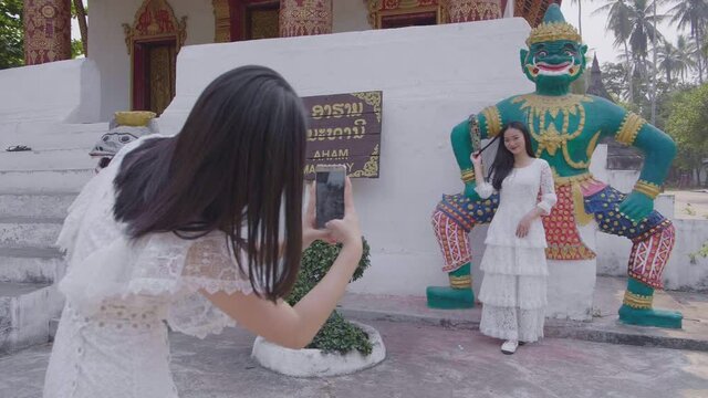 Girl Taking Picture Of Another Girl Near Temple, Slow Motion 
